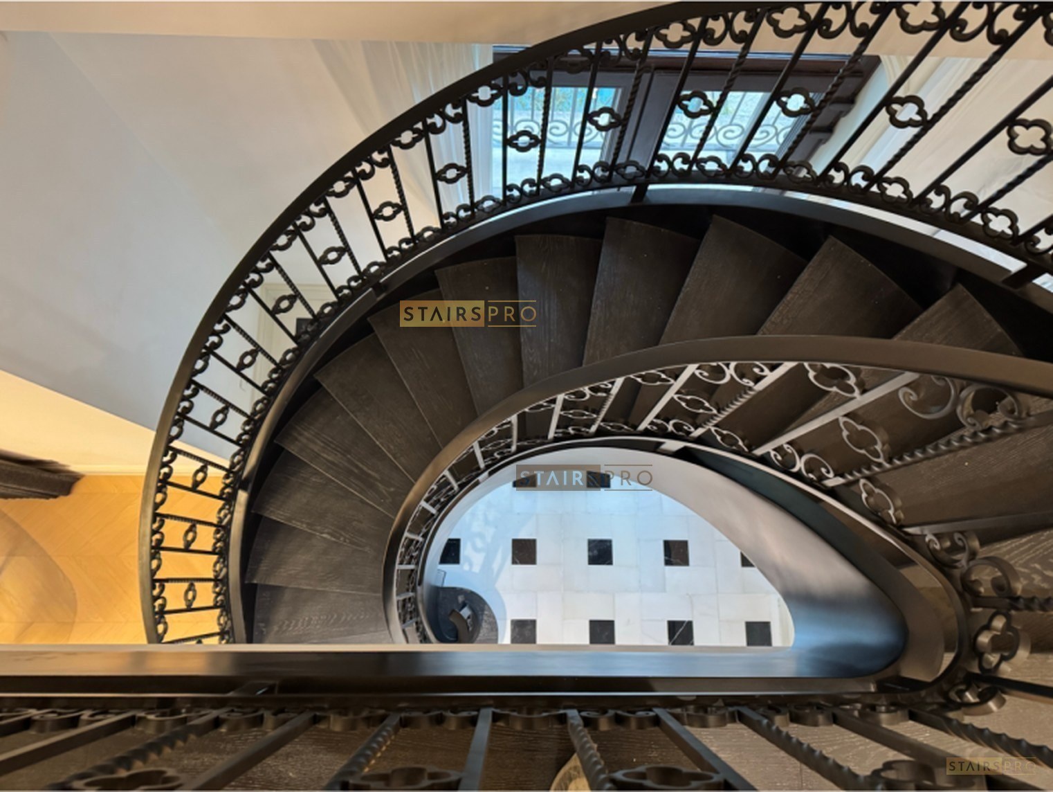Curved staircase with solid timber treads on a rolled steel spine