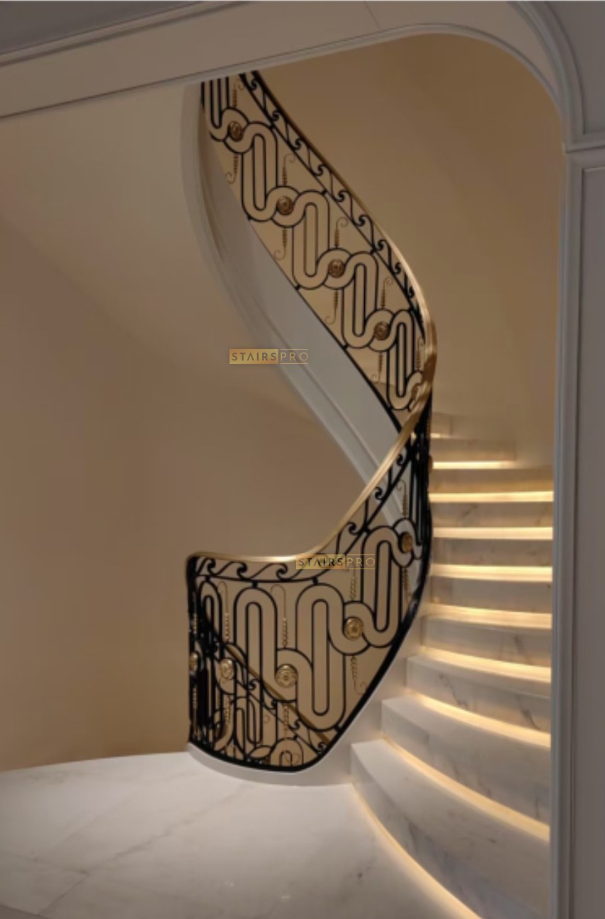 Gilded wrought iron balustrade curving over lit marble treads