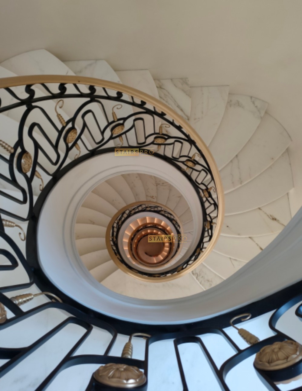Scrolled wrought iron balustrade on a spiral staircase seen from above