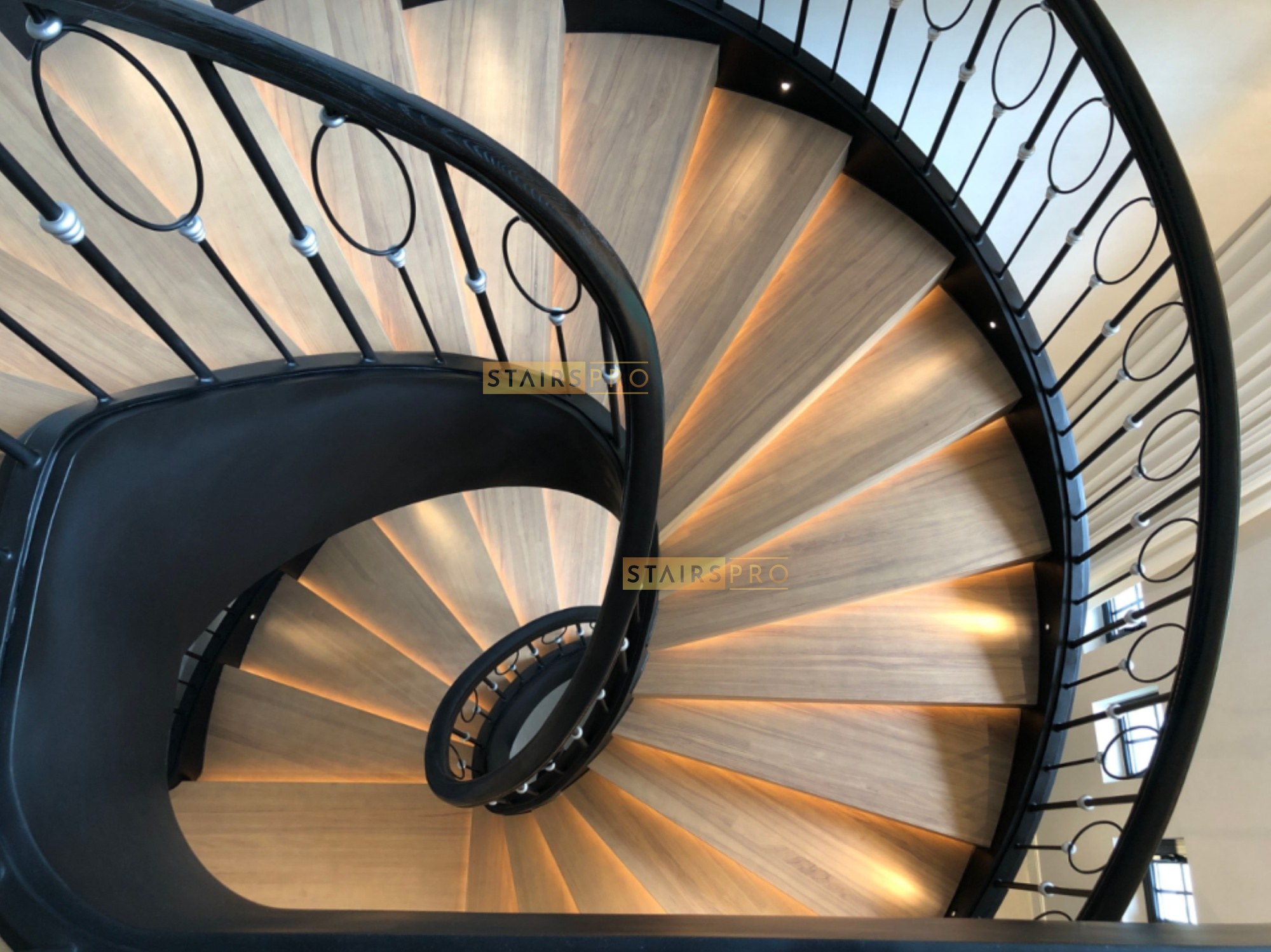 Curved wrought iron balustrade with solid timber handrail