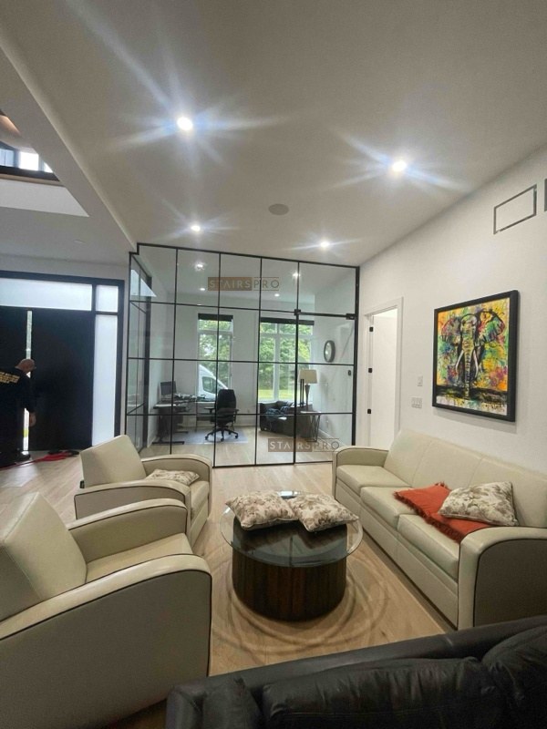 Interior glass partition seen from the living room, steel framed in black