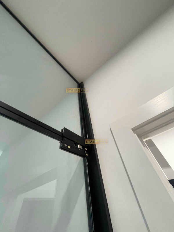 Slim black frame junction on an interior glass partition