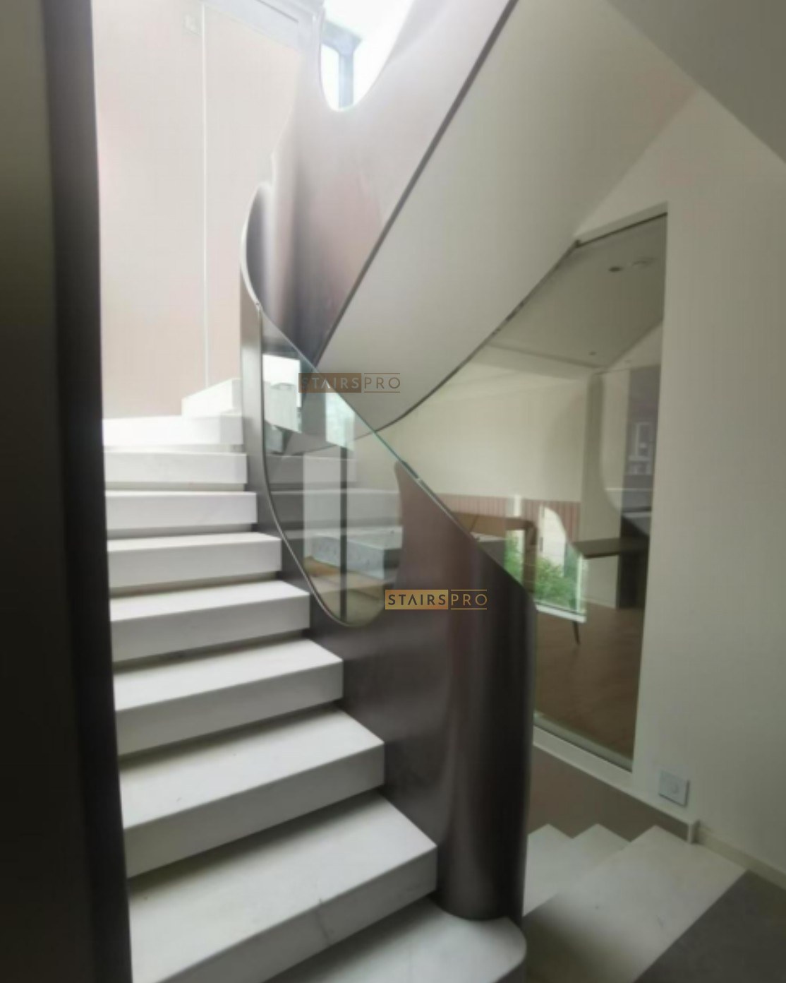 Curved steel balustrade panel beside a staircase flight