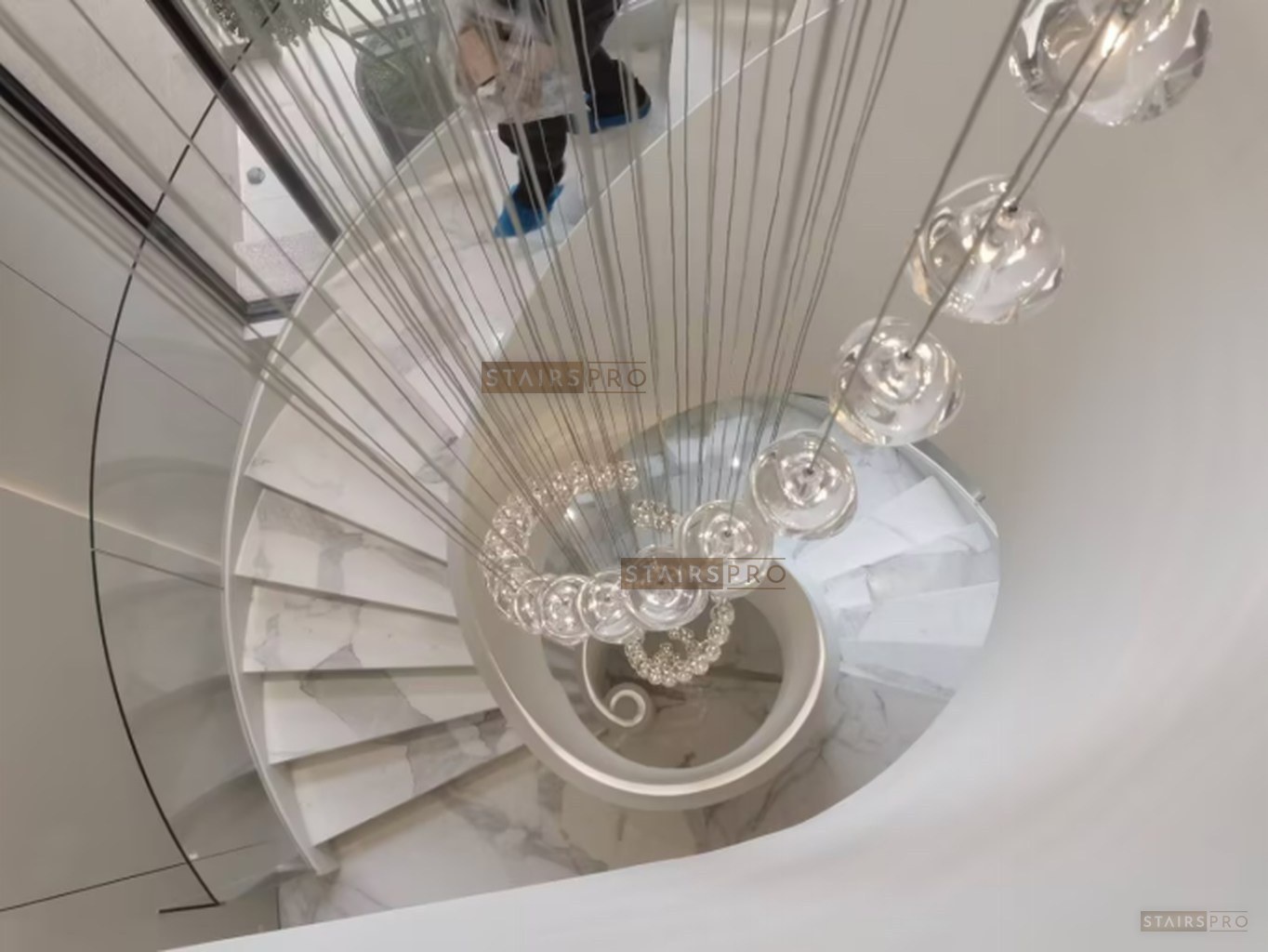 Luxury curved staircase with stone treads and a glass balustrade